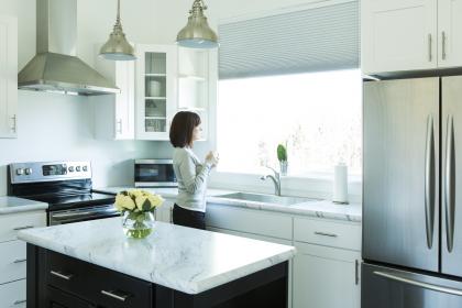 Woman standing in kitchen with new appliances