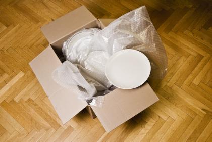 Box with dishes wrapped in packing materials