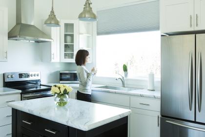 Woman standing in kitchen with new appliances