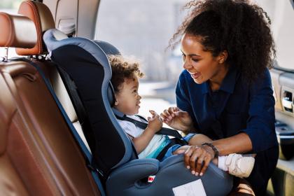 Woman Securing Her Toddler to Childseat in Car