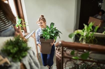 Woman Moving Plants Upstairs