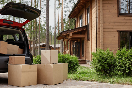 Moving boxes in driveway of wooden cabin