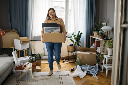 Woman packing moving boxes in livingroom